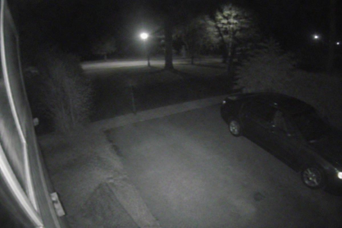 Dark, grainy night-time CCTV image of a driveway where detail is hard to make out